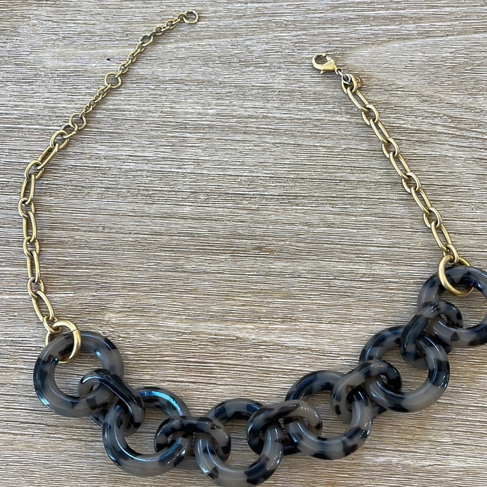 Grey tortoise and brass necklace.